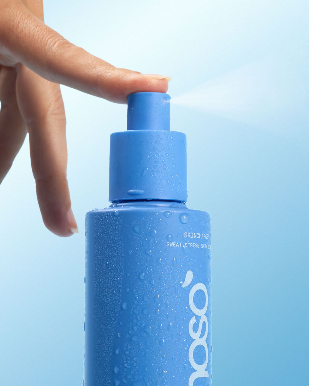 Hand holding a blue bottle with a blue cap against a light blue background